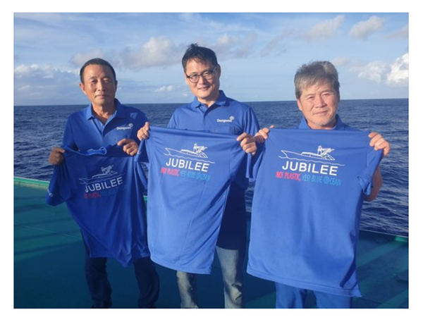 동원산업 임직원들이 해양 투기 플라스틱을 줄이자는 글이 적힌 티셔츠를 들고 있다. / 동원산업